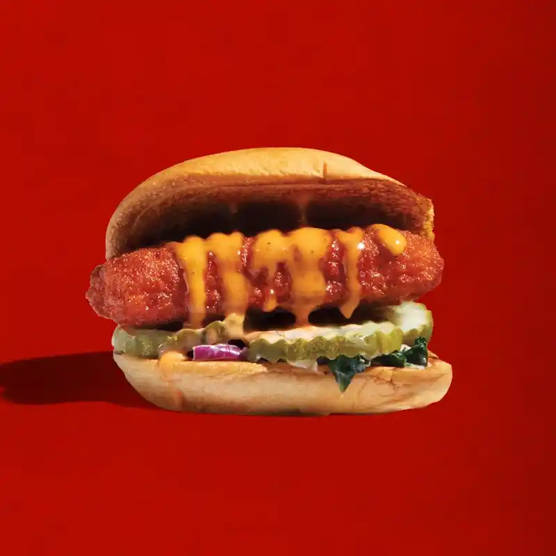 Dave’s Hot Mozz slider with mozzarella stick, kale slaw, pickles, and sauce in bun